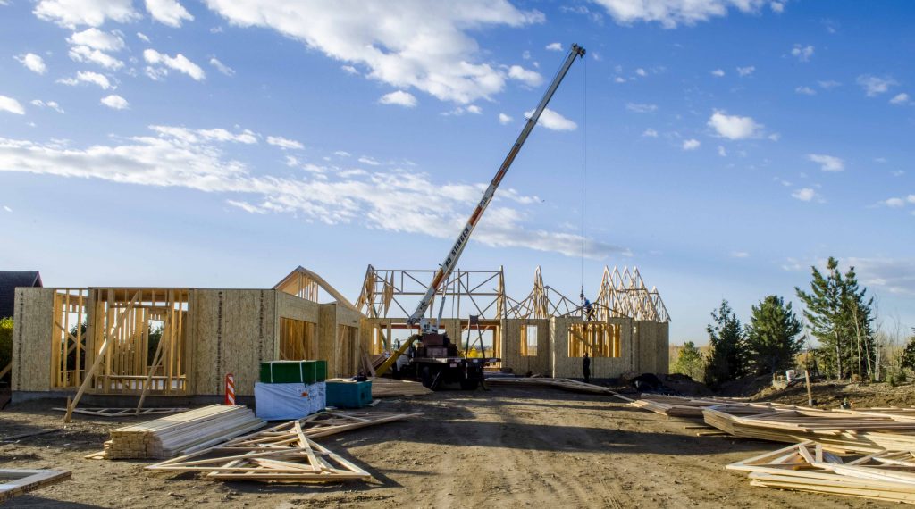 Crane lifting rafters into place on new home construction